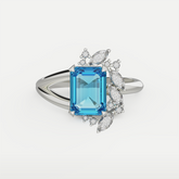Front-facing view of a statement blue gemstone ring with a radiant emerald cut and clustered white stones.