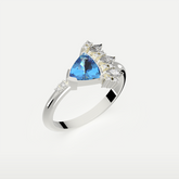 Celestial Crest gemstone ring side view with trillion-cut Blue Topaz set in silver crown-inspired design