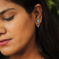 Elegant woman wearing Celestial Arc Drop Earrings with Blue Topaz, styled with evening wear