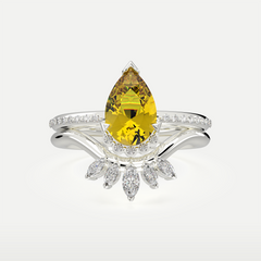 Silver ring featuring a pear-cut gemstone and delicate marquise accents, displayed in close-up to highlight the craftsmanship and gemstone brilliance.